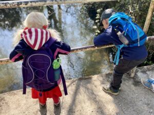 children gazing with wonder down into a river